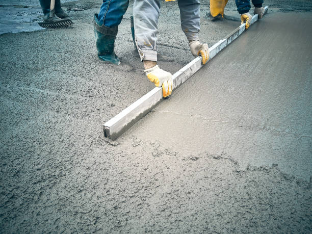 Worker applying concrete patch repair to damaged walkway surface area