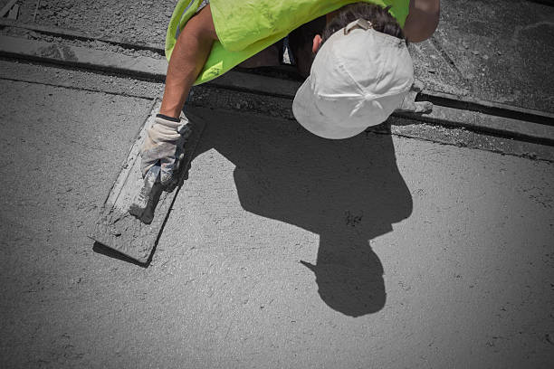 Concrete repair technician sealing cracks in driveway in Martindale TX