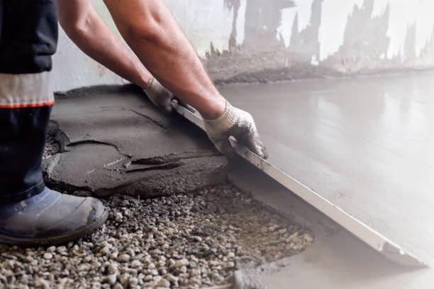 Worker applying concrete resurfacing material to worn patio area 