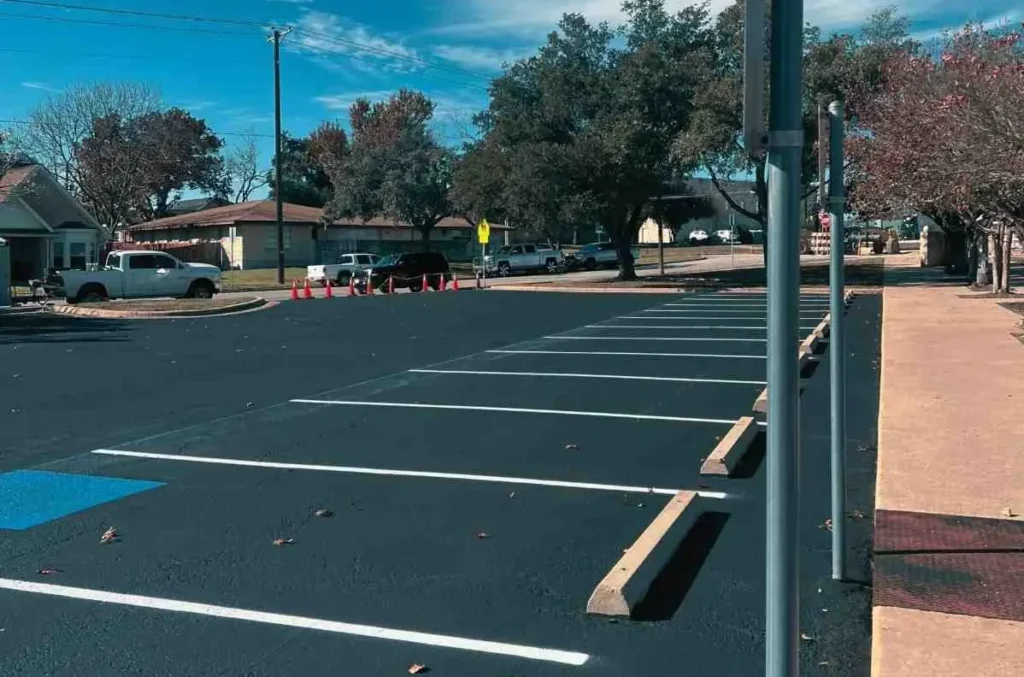 Targeted parking lot restriping reconnecting existing markings around repaired pavement in Martindale, TX. Parking lot striping near me